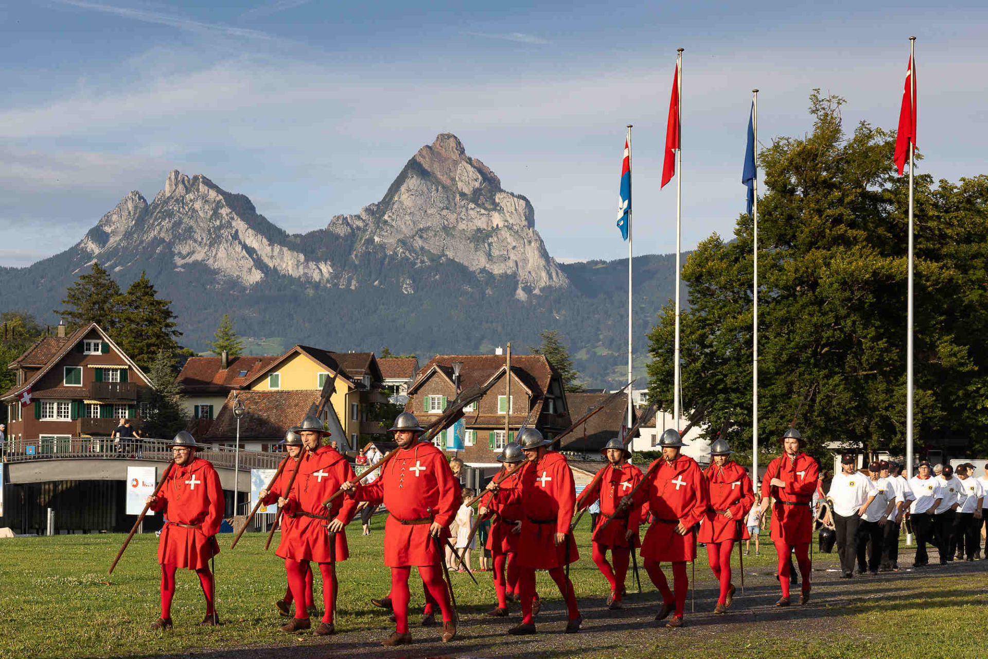 Die roten Schwyzer laufen über den Auslandschweizerplatz mit den Mythen im Hintergrund