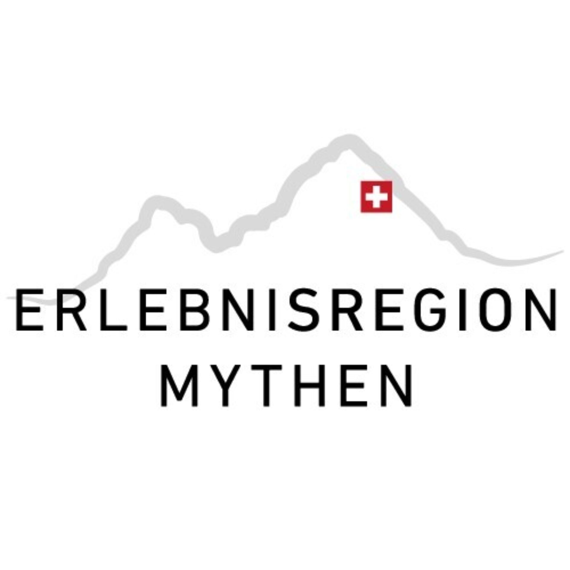 Man sieht das in schwarz geschriebene Logo der Erlebnisregion Mythen hinter der Schrift sind die beiden Mythen umrisse in Grau zu sehen mit einem Schweizerkreuz