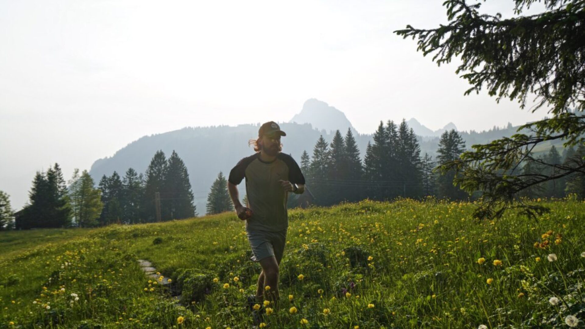 Simon Kunz auf Trailrunning durch eine Sommer-Blumenwiese in den Schwyzer Voralpen.