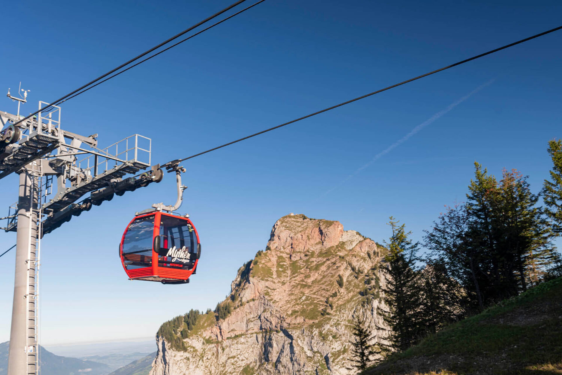 rote Gondel der Rotenfluhbahn im Hintergrund die Myten.