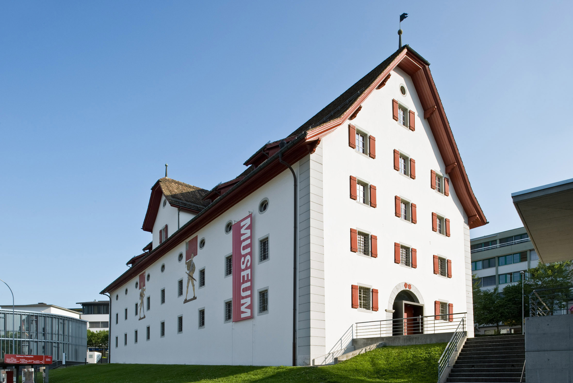 Aussenansicht des Forum Schweizer Geschichte Schwyz. Das historische Zeughaus mitten in Schwyz ist ein imposantes weisses Gebäude mit vielen Fenstern.